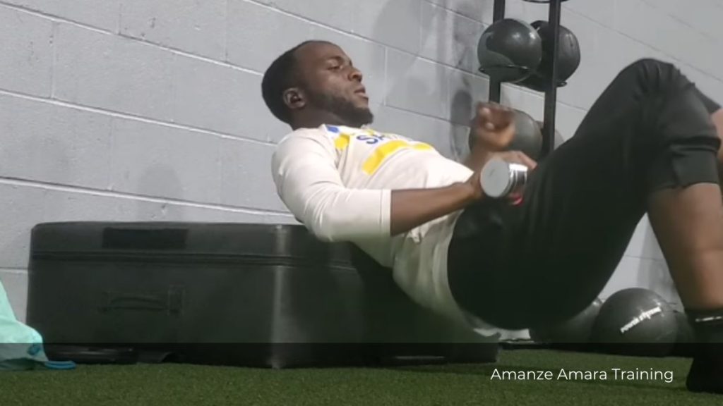 Soccer player performing a single-leg glute bridge with dumbbell on bench – Amanze Amara Training