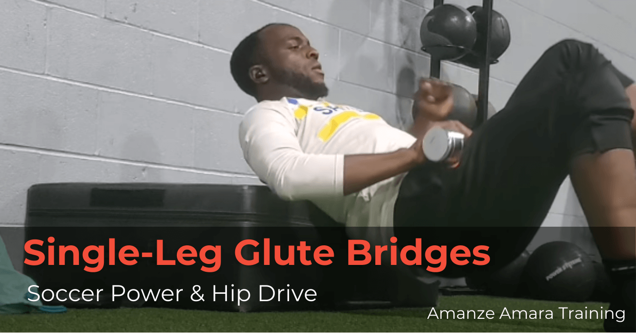Soccer player performing single-leg glute bridge on a gym box with a dumbbell for hip strength and stability