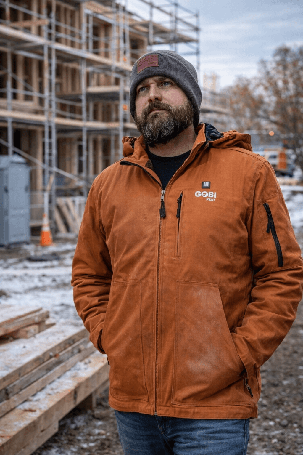 Heated work jacket worn on a cold construction job site demonstrating rugged outer shell durability